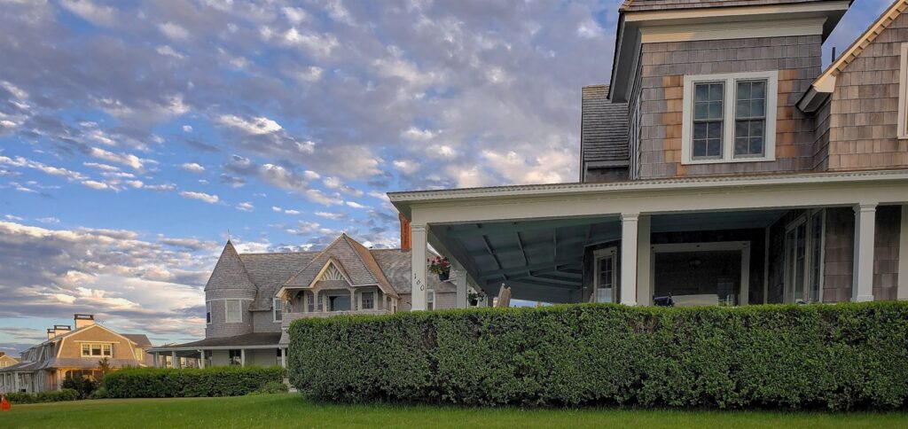 Cedar-shingled coastal homes with steep pitched roofs along a Jersey Shore street